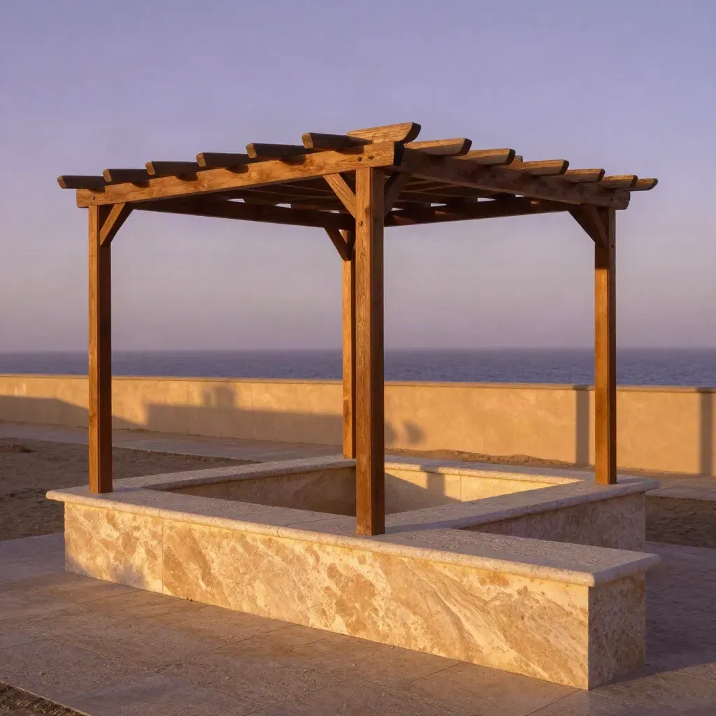 Patio costero de piedra al atardecer, con pérgola de madera y cielo dorado.